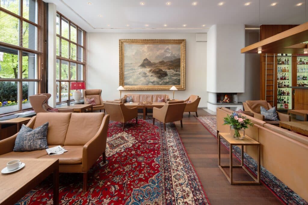 Baseler Hof Foyer mit Ledersesseln, Wandgemälde und Bar